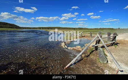 Maidens Grave Hot Spring flowing into the Firehole River in Yellowstone National Park in Wyoming United States Stock Photo