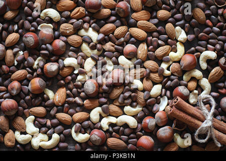 Different nuts on a wooden table. Cedar, cashew, hazelnut, walnuts and a spoon on the table. Many nuts are inshell and chistchenyh on a wooden backgro Stock Photo