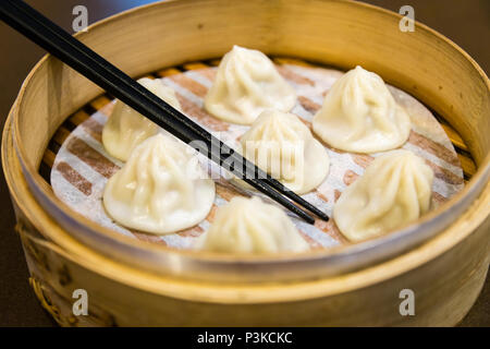 Traditional Chinese steamed dumplings in a bamboo steamer Stock Photo