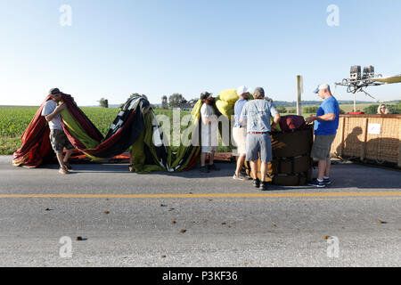 Passengers helping with folding hot air balloon after flight, Lancaster County, Pennsylvania, USA Stock Photo