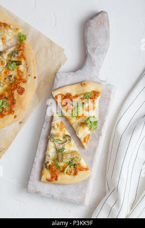 two pieces of white pizza with artichoke and arugula Stock Photo