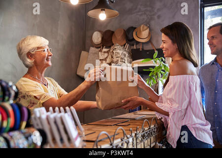 Store Owner Standing Behind Cash Desk Serving Customers Stock Photo