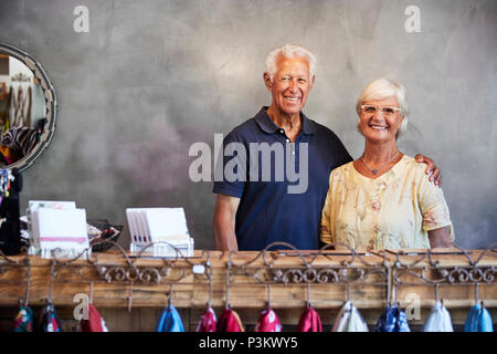 Portrait Of Senior Store Owners Standing Behind Cash Desk Stock Photo