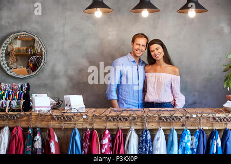 Portrait Of Store Owning Couple Standing Behind Cash Desk Stock Photo