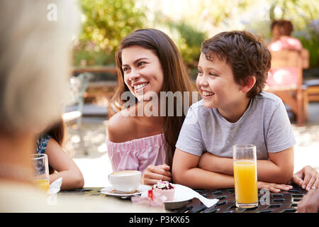 Multi Generation Family Enjoying Snack At Outdoor Café Together Stock Photo