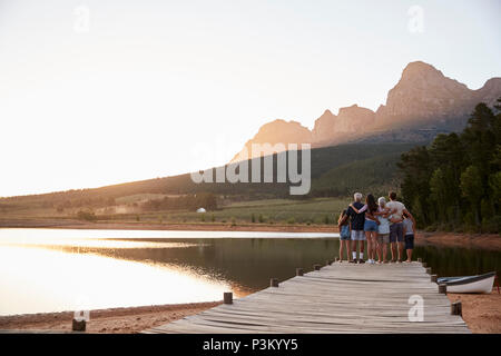 Rear View Of Multi Generation Family Standing On Jetty By Lake Stock Photo