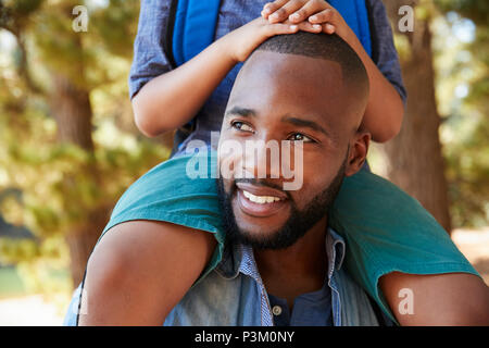 Close Up Of Father Walking In Woods Carrying Son On Shoulders Stock Photo