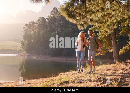 Couple Enjoying Walk By Lake On Family Hiking Adventure Stock Photo
