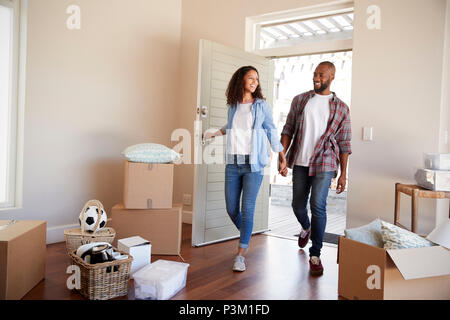 Couple Holding Hands Walk Into New Home On Moving Day Stock Photo