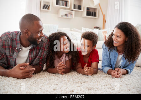 Family Lying On Rug In Lounge At Home Stock Photo