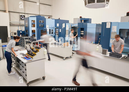 Busy Engineering Workshop With Workers Using CNC Machinery Stock Photo