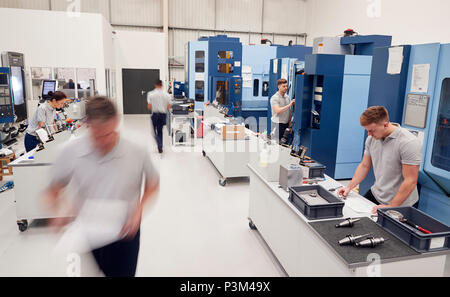Busy Engineering Workshop With Workers Using CNC Machinery Stock Photo