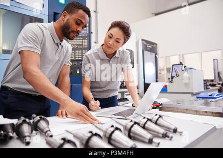 Two Engineers Using CAD Programming Software On Laptop Stock Photo