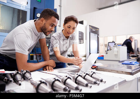 Two Engineers Using CAD Programming Software On Laptop Stock Photo