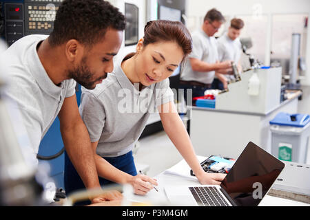Two Engineers Using CAD Programming Software On Laptop Stock Photo