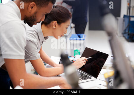 Two Engineers Using CAD Programming Software On Laptop Stock Photo