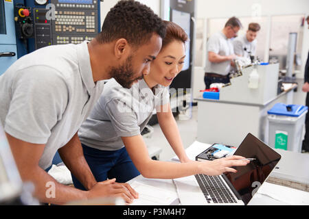 Two Engineers Using CAD Programming Software On Laptop Stock Photo