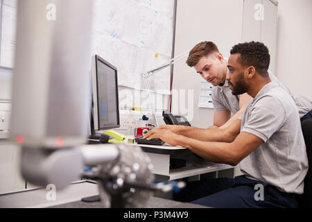 Male Engineers Use CMM Coordinate Measuring Machine In Factory Stock Photo