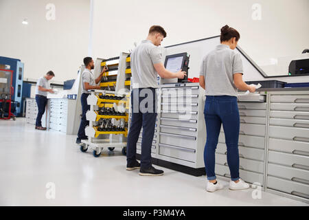 Engineers Selecting Tools For Use On Machinery In Factory Stock Photo