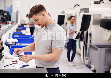 Male Engineer Quality Controlling Components In Factory Stock Photo