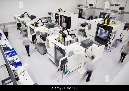 Overhead View Of Engineering Workshop With Workers Using CNC Machinery Stock Photo