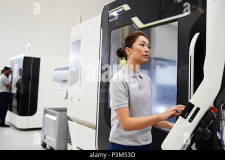Female Engineer Operating CNC Machinery In Factory Stock Photo