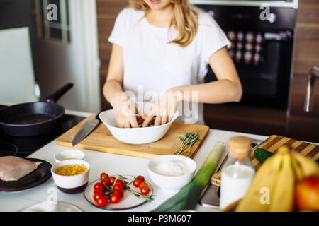 Home cozy kitchen chef pours salt on pork or beef meat with salt shaker Barbecue concept or healthy meat lifestyle shot Stock Photo