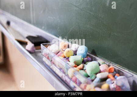 Some old color chalk in a dusty blackboard Stock Photo