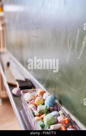 Some old color chalk in a dusty blackboard Stock Photo