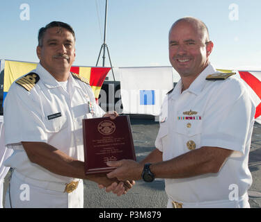 SAN DIEGO (July 5, 2016) Rear Adm. James Kilby, Commander, Naval Surface and Mine Warfare Development Center, right, presents Mexican navy Capt. Sergio Serrallonga Sanchez, Commander, Naval Flotilla of Destroyers of Pacific Naval Forces, with a plaque commemorating the two countries’ partnership as part of the Southern California portion of the Rim of the Pacific (RIMPAC) 2016 exercise during a reception aboard the Mexican navy tank landing ship ARM Usumacinta (A-412). Twenty-six nations, more than 40 ships and submarines, more than 200 aircraft and 25,000 personnel are participating in RIMPAC Stock Photo