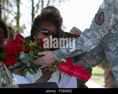 A Soldier from the 200th Military Police Command presents Robin Churn, Maj. Gen. Phillip M. Churn’s wife, a bouquet of red roses in appreciation of her attributions to the unit during the 200th MP Cmd’s relinquishment of command ceremony at the McGlachlin Parade Field, at Fort Meade, Md., July 10, 2016.  Lieutenant General Charles D. Luckey, chief of the Army Reserve and commanding general of the United States Army Reserve Command, was the reviewing official for the ceremony, in which Maj. Gen. Phillip M. Churn relinquished command to Brig. Gen. Marion Garcia. (U.S. Army photo by Spc. Stephani Stock Photo