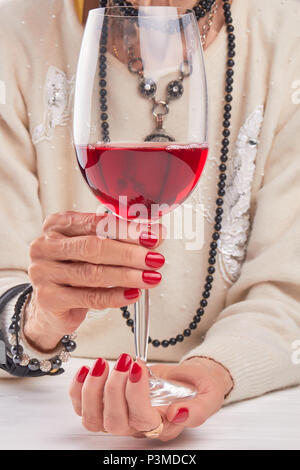 Large glass of wine in female hands.