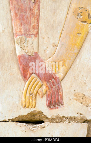 Colorfully painted bas relief stone carvings of a king and queen holding hands at the Great Osiris Temple, Abydos, Egypt. Stock Photo