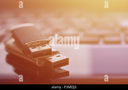 USB flash cards lying on black laptop case in front of his keyboard. Virtual memory storage with USB output Stock Photo