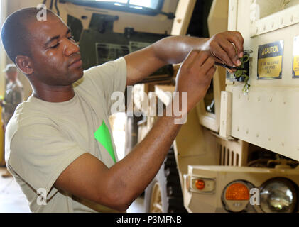 Spc. Lamine Traore, from the New York Army National Guard's  Battery B,  1st Battalion, 258th Field Artillery, attaches the last sensor for the Multiple Integrated Laser Engagement System to an armored tactical at Fort Polk, La., on Monday, July 11, 2016.   More than 3,000 New York Army National Guard Soldiers deployed to Fort Polk, Louisiana for a three week exercise at the Army’s Joint Readiness Training Center, July 9-30, 2016. Stock Photo