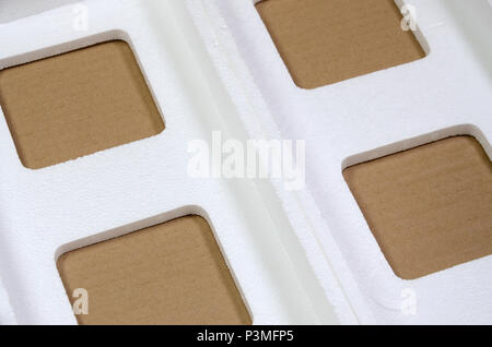 Background image with beige cardboard paper and styrofoam boxes disgarded as rubbish. The concept of unpacking new home appliances out of the carton b Stock Photo