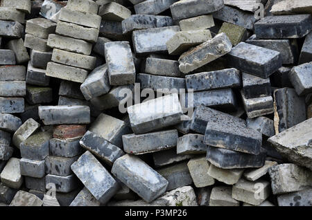 A large pile of disassembled paving slabs. A lot of square stones before the reconstruction of the pavement site Stock Photo
