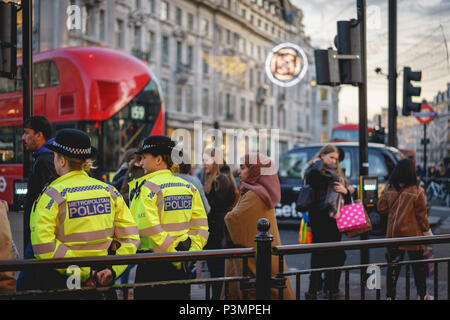 London, UK - November 2017. Two police officers patrolling and assisting people at Oxford Circus during Christmas time. Landscape format. Stock Photo