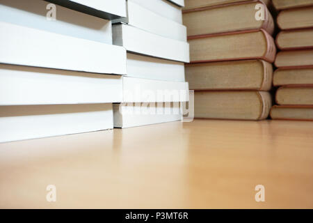 Old books and new books stacked up on the wooden desk in library or bookstore Stock Photo