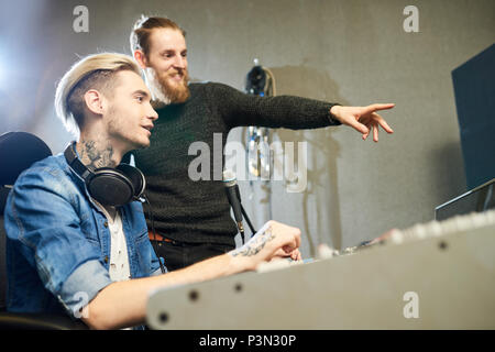 Cheerful colleagues making music in studio Stock Photo