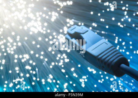 Futuristic technological background, closeup on the end of optical fiber network cable on blue background Stock Photo
