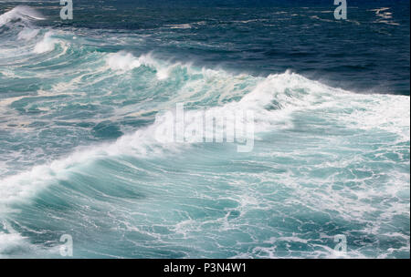 Splashing sea water with foam and bubbles at Timang Beach in sunny day, Yogyakarta, Indonesia Stock Photo