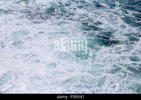 Splashing sea water with foam and bubbles at Timang Beach in sunny day, Yogyakarta, Indonesia Stock Photo