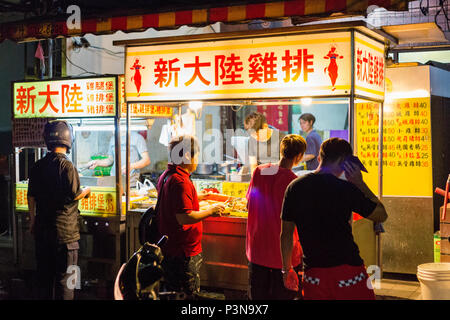 TAICHUNG, TAIWAN - AUGUST 22: This is a traditional Taiwanese street food stand with people waiting to buy food at night on August 22, 2014, in Taichu Stock Photo