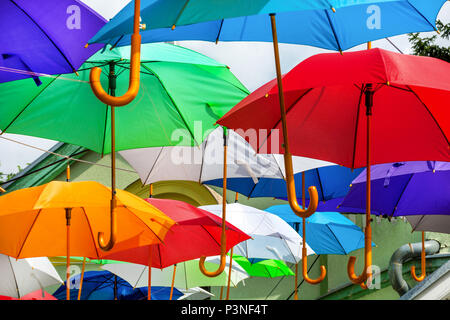 Colorful umbrellas urban street decoration. Hanging colorful umbrellas over blue sky, tourist attraction on sunny day. Close up, selective focus Stock Photo
