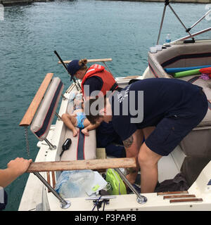 Seaman Amanda Wolf, a boat crew member from Coast Guard Station Wilmette Harbor in Chicago, Illinois, performs CPR on a child aboard a vessel in Lake Michigan, July 21, 2016. Wolf successfully resuscitated the girl while in transit to Navy Pier. (U.S. Coast Guard photo) Stock Photo