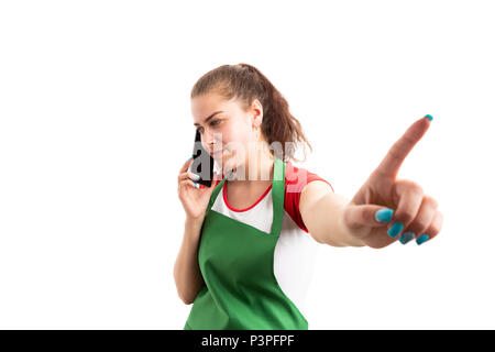Saleswoman or assistant using smartphone and making hold gesture with index finger as important employee call concept isolated on white background Stock Photo