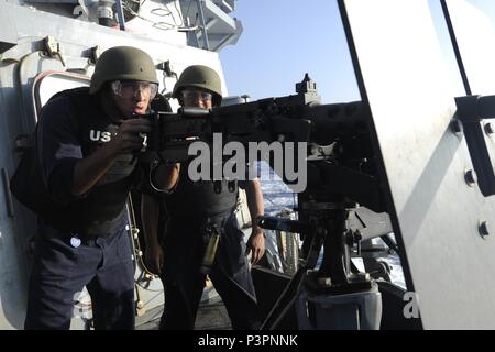160721-N-MX772-012  PACIFIC OCEAN (July 21, 2016) Gunner’s Mate Seaman George Fernandez fires a .50 caliber machine gun as Gunner’s Mate 2nd Class Matthew Avila watches on the fo’c’sle of the Arleigh Burke-class guided-missile destroyer USS Howard (DDG 83). Howard is currently underway participating in Rim of the Pacific Exercise 2016. Twenty-six nations, more than 40 ships and submarines, more than 200 aircraft and 25,000 personnel are participating in RIMPAC from June 30 to Aug. 4, in and around the Hawaiian Islands and Southern California. The world’s largest international maritime exercise Stock Photo