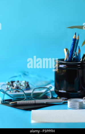 Turquoise blue styled desktop, black white stationery, optical glasses and blank copy space. Working from home office. Studying, freelancing concept. Stock Photo