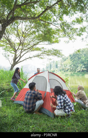 tourist help each other prepare tent Stock Photo